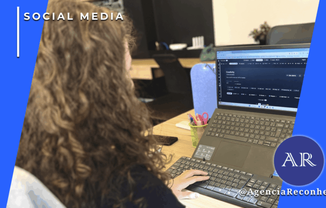 Mulher com cabelos cacheados vista de costas trabalhando em um notebook que exibe uma interface de plataforma de inteligência artificial em um escritório moderno, com o selo da Agência Reconhecida.