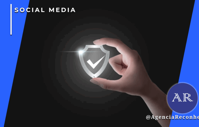 Mão segurando um holograma de escudo prateado com checkmark de segurança, com moldura azul lateral e logotipo "AR - Agência Reconhecida" no canto inferior.