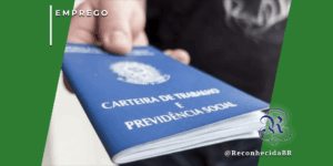 Close-up de uma mão segurando a Carteira de Trabalho e Previdência Social (CTPS) azul do Brasil, representando a liderança do país no ranking global de intenções de contratação para o início de 2026.