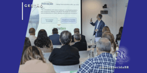 Palestrante apresenta slides sobre inovação e gestão para uma plateia de executivos brasileiros em sala de aula no MIT, Boston. O slide exibe a fórmula "Technological Knowledge + Management Knowledge". Foto com selos Gestão e ReconhecidaBR.