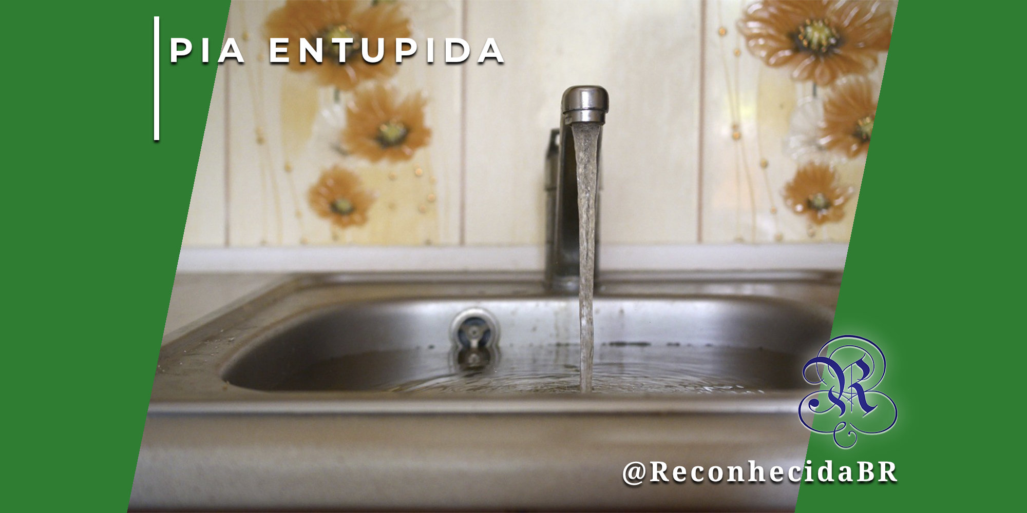Close de uma pia de cozinha de metal cheia de água parada e suja, indicando entupimento. A torneira está aberta, despejando um fio de água. No canto superior esquerdo, o selo 'PIA ENTUPIDA' em branco; no inferior direito, o logotipo do portal Reconhecida com o @ReconhecidaBR.
