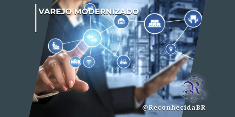 Mulher em blazer escuro estende a mão esquerda para tocar um gráfico holográfico luminoso e circular azul de conexões logísticas. Enquanto isso, com a mão direita, ela segura um tablet fino e inclinado. O gráfico exibe ícones vetoriais interligados que representam ferramentas como wifi, código de barras, empilhadeira, geolocalização e galpão de distribuição. Ao fundo e de forma desfocada, aparecem as prateleiras de um centro de distribuição ou estoque de mercadorias. No canto superior esquerdo, lê-se o selo VAREJO MODERNIZADO em letras brancas; no inferior direito, o logotipo do portal Reconhecida com o @ReconhecidaBR.
