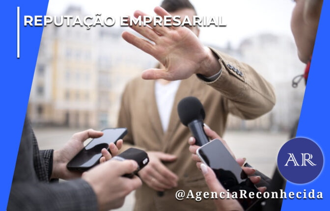 Homem com paletó bege estende a mão espalmada para frente, tentando cobrir a câmera ou evitar uma entrevista. Em primeiro plano, repórteres seguram microfones, gravadores e smartphones em sua direção. No topo esquerdo, lê-se o texto "Reputação Empresarial" e, no canto inferior direito, o selo redondo azul com as letras "AR" e o texto @AgenciaReconhecida.