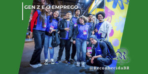 Grupo de jovens sorridentes, homens e mulheres, posando juntos em um evento corporativo ou feira de profissões. A maioria veste camisetas azuis idênticas com crachás de identificação pendurados. No topo esquerdo da imagem, há o texto "Gen Z e o Emprego" e, no canto inferior direito, o logotipo clássico do portal Reconhecida com a assinatura @ReconhecidaBR.