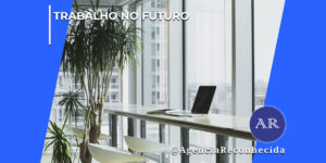 Escritório corporativo moderno e luminoso com uma bancada branca comprida paralela a uma grande janela de vidro que dá vista para prédios urbanos. Sobre a bancada, há um notebook aberto de perfil. Duas cadeiras brancas modernas estão organizadas sob a mesa e, à esquerda, destaca-se um vaso com uma planta Dracena grande. No topo esquerdo da imagem, lê-se o texto "Trabalho no Futuro" e, no canto inferior direito, o logotipo redondo azul com as letras "AR" e o texto @AgenciaReconhecida.